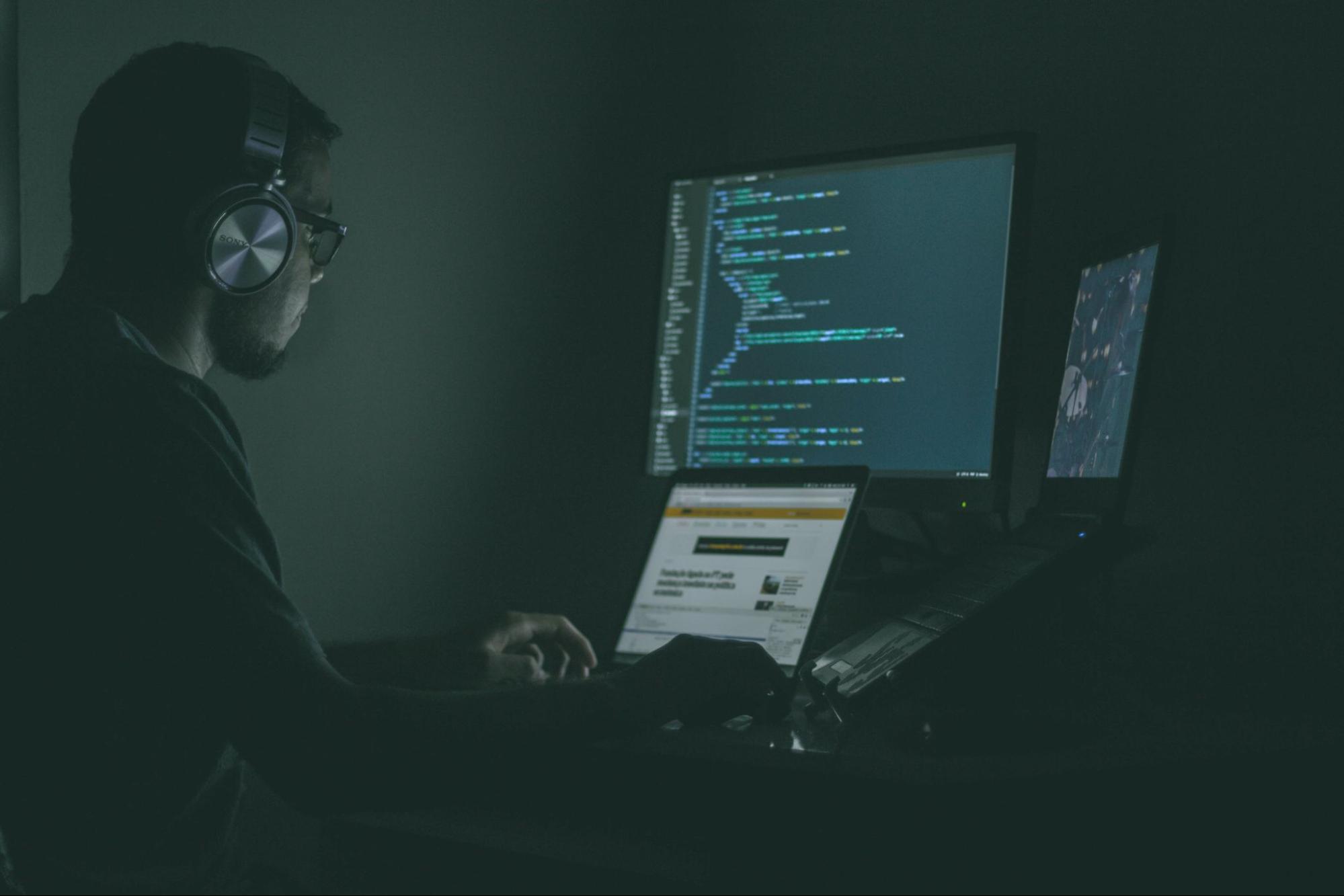 man working on code, wearing headphones